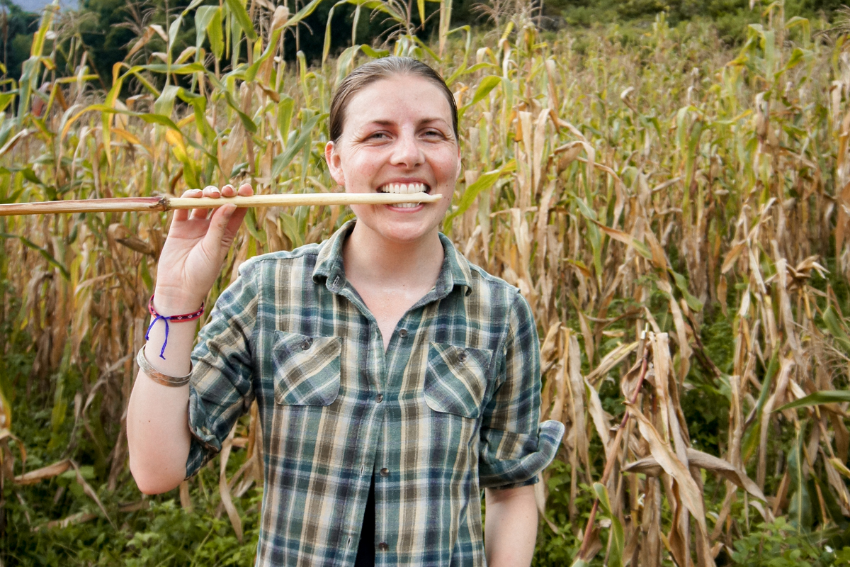 Australian travel writer Jessica Korteman in a corn field in Sapa, Vietnam chewing on a corn stalk from harvest.